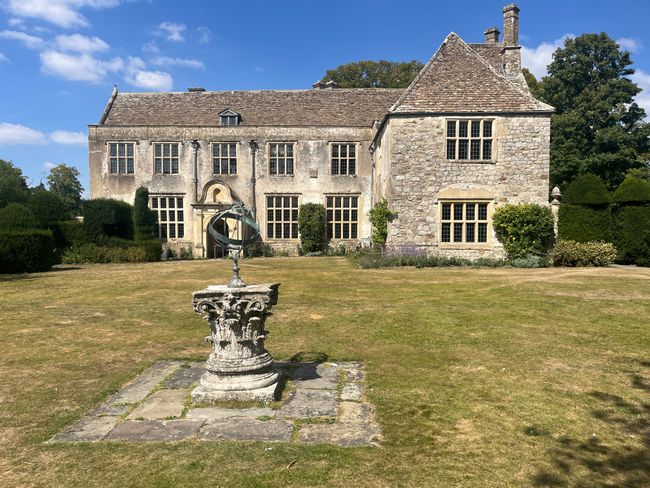 A large Manor house with foutain in front