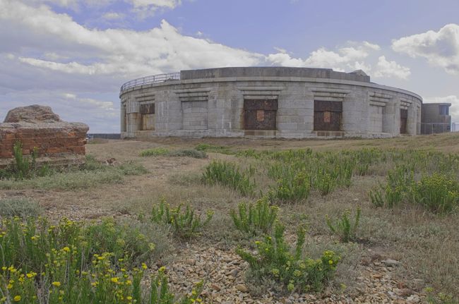 A round stone building with holes for anti ship and aircraft guns.