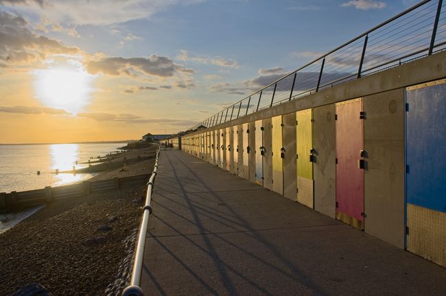 Beach huts with coloured doors in the setting sun