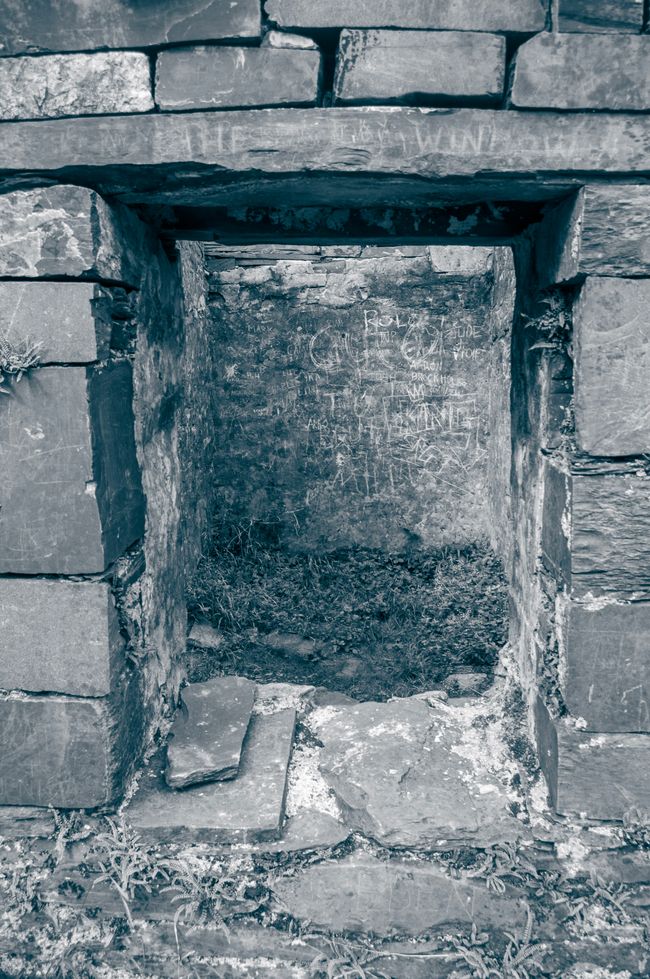 A view through the window of one of the old cottages where the stone has scratch marks